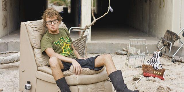 homeless man sitting outside with beer