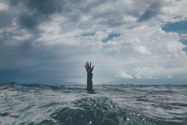 howtogetsober person reaching out their hand in ocean