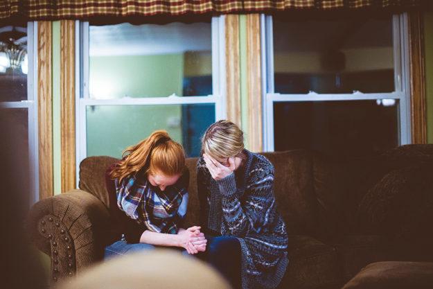 mom and daughter crying on the couch