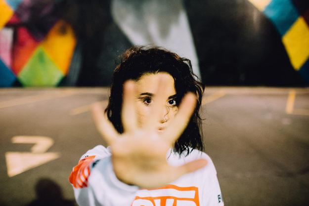 howtopreventdrugaddiction girl with black hair looking up with her hand inront of camera
