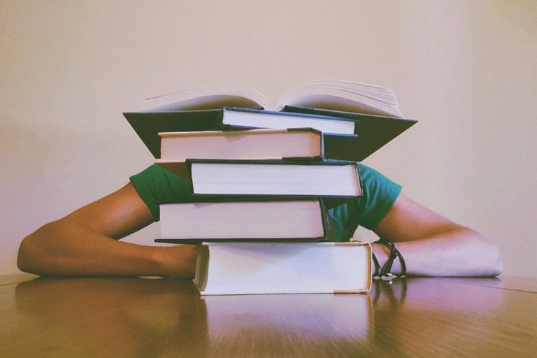 girl with her head in stacked books