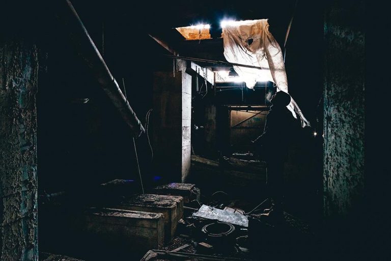 man looking up from a trap door