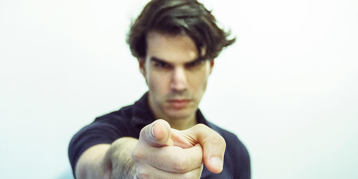 man pointing to the camera in blue shirt
